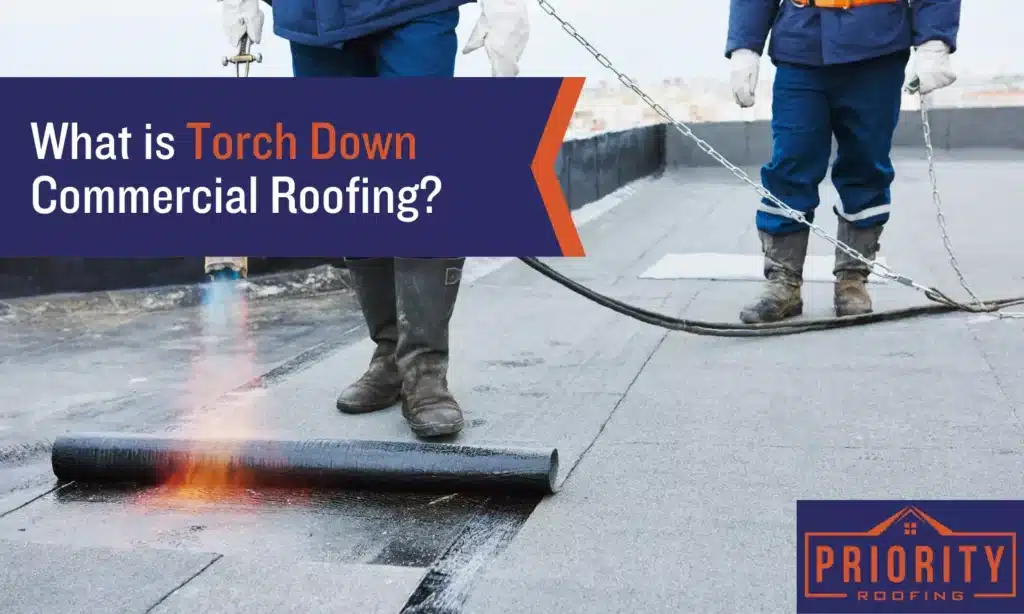 Roofers installing a torch-down modified bitumen membrane on a flat commercial roof with open flame torch, Priority Roofing branding in corner.