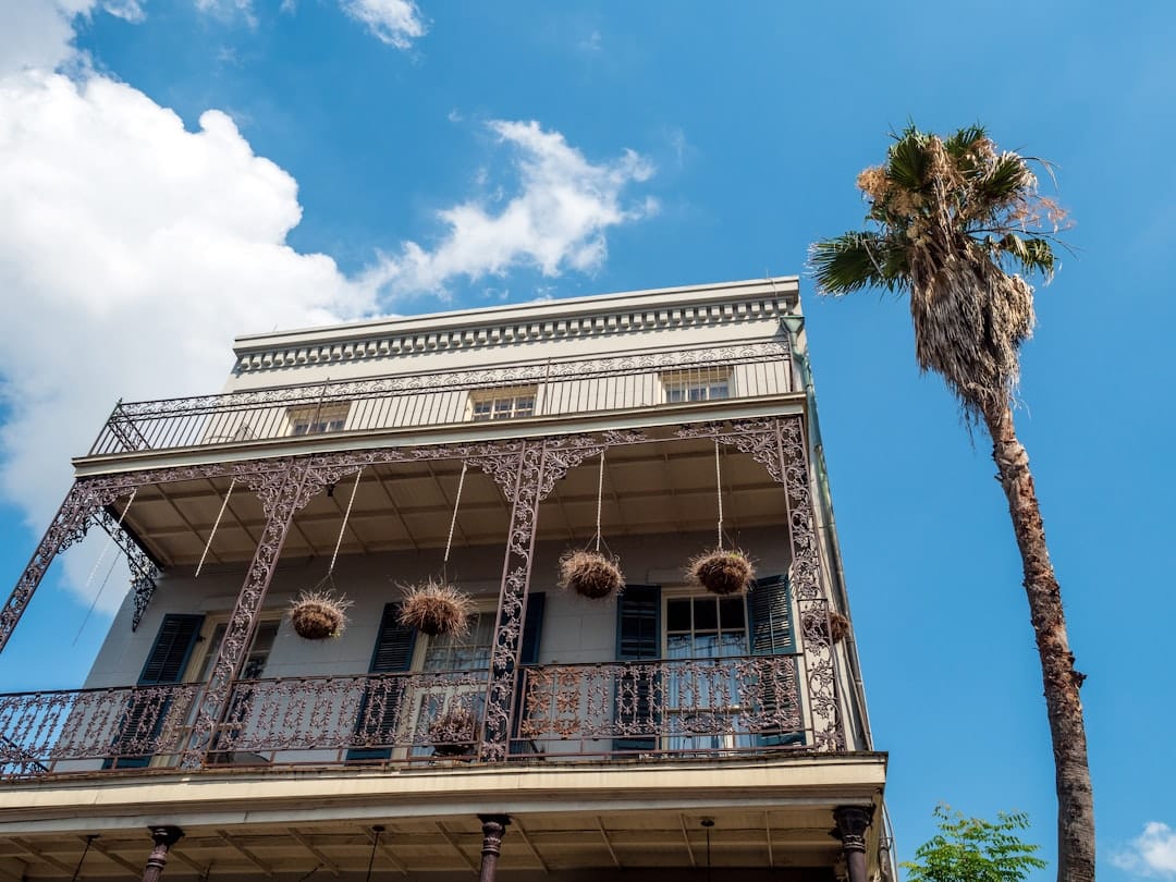 A bright and sunny photo of a well-maintained New Orleans shotgun house, showcasing a sturdy, secure roof ready for any weather.