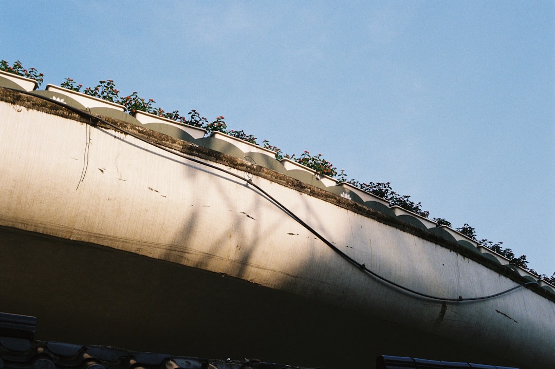 A detailed, macro shot showing the precise installation of metal flashing around a chimney on a residential roof, highlighting quality craftsmanship.