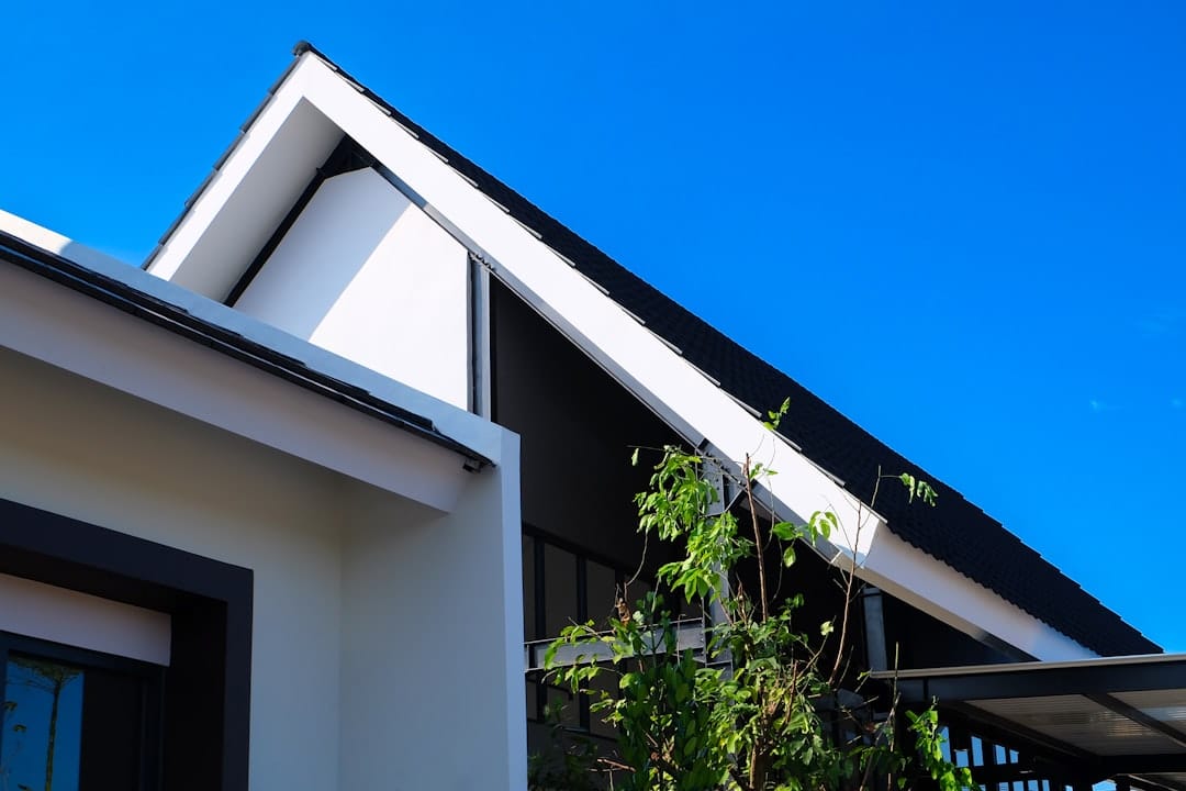 The clean, sturdy roof of a modern house shining in the bright sun after a storm, symbolizing resilience and protection.