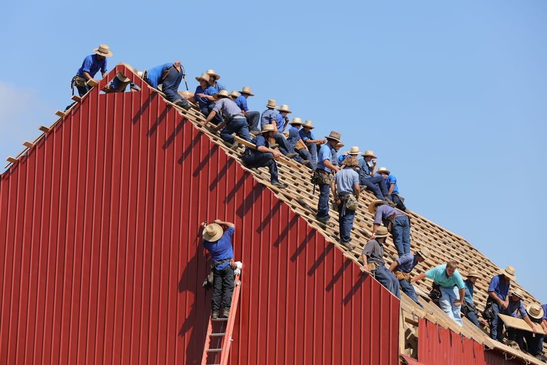 A detailed close-up shot of a professional roofer expertly nailing down durable architectural shingles on a sunny day.