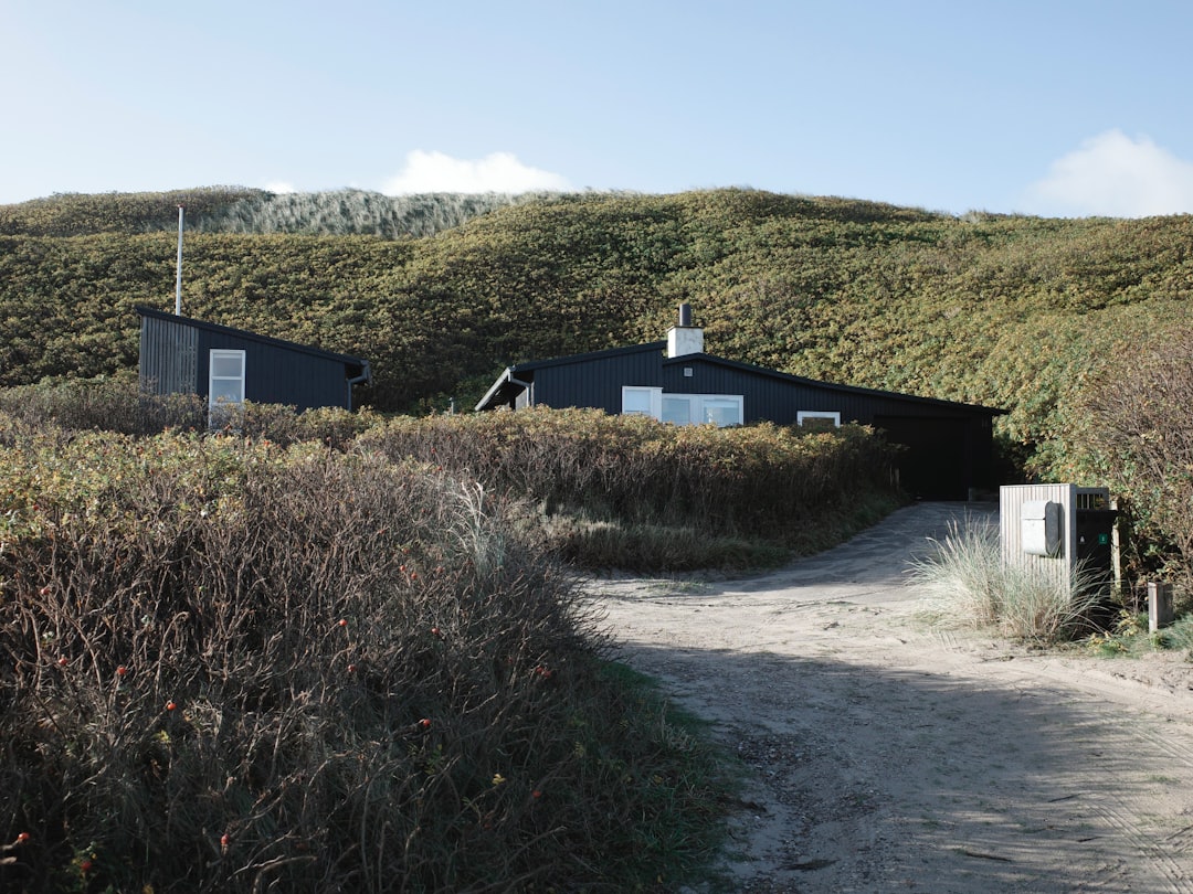 A beautiful, modern coastal home with a brand new, sturdy roof gleaming under a clear, sunny sky, representing security and a successful recovery.