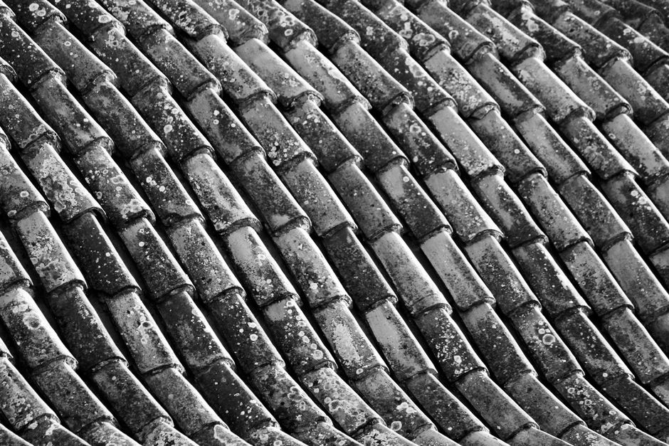 A detailed close-up photo of high-quality architectural roofing shingles, showing their texture, layers, and durability.