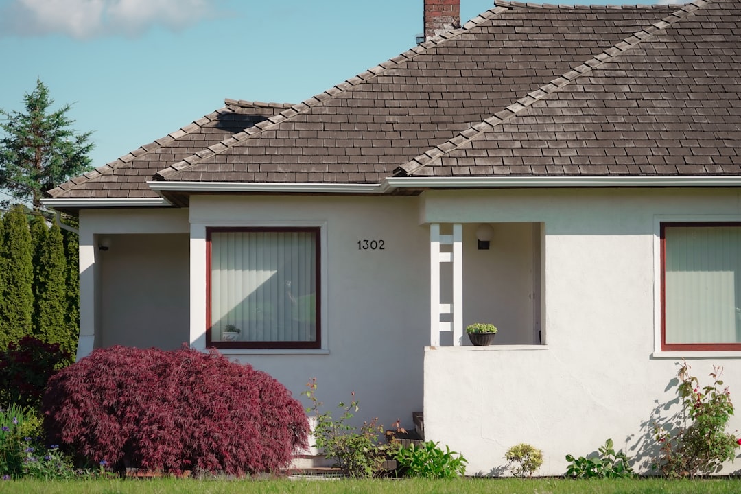 A wide shot of a clean, modern home with a brand new, perfectly installed asphalt shingle roof, symbolizing a long-term investment and the value of a full roof replacement.