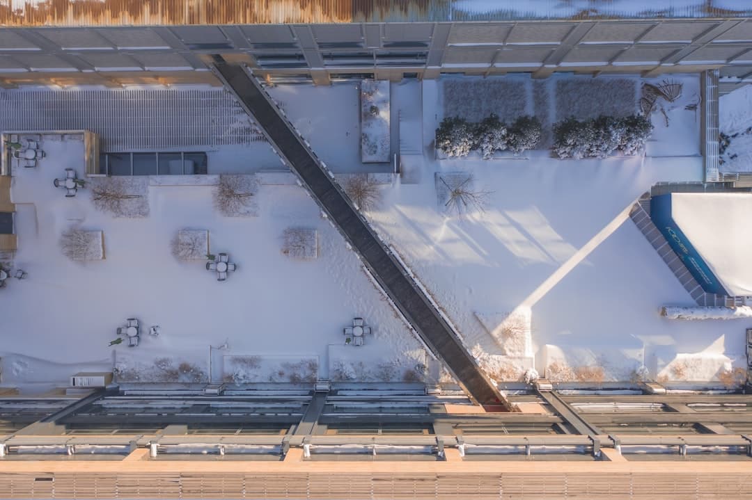 An aerial drone shot of a vast, clean, and well-maintained white TPO roof on a modern commercial property, representing a secure and prepared investment.