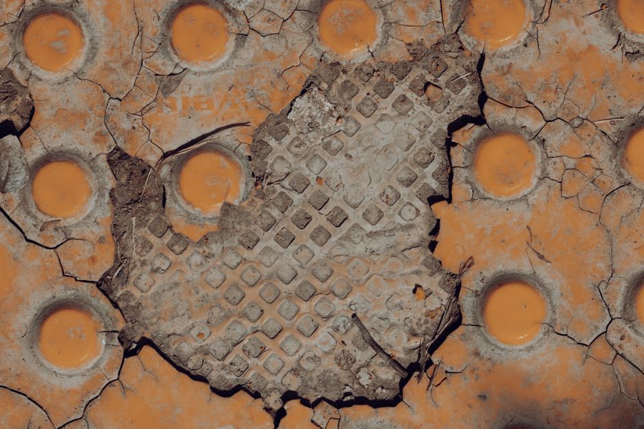 Close-up photograph of a stained and sagging ceiling tile in a commercial office, indicating a serious water leak from the...